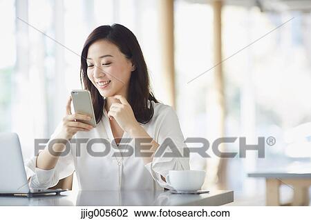 Japanese woman with smartphone in a stylish cafe View Large Photo Image Stock Image - Japanese woman with smartphone in a stylish cafe. Fotosearch