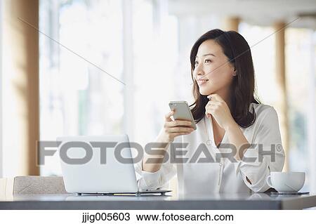 Japanese woman with smartphone in a stylish cafe View Large Photo Image Stock Image - Japanese woman with smartphone in a stylish cafe. Fotosearch