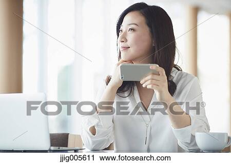 Japanese woman with smartphone in a stylish cafe View Large Photo Image Stock Image - Japanese woman with smartphone in a stylish cafe. Fotosearch