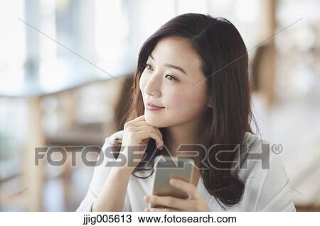 Japanese woman with smartphone in a stylish cafe View Large Photo Image Stock Image - Japanese woman with smartphone in a stylish cafe. Fotosearch