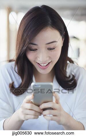 Japanese woman with smartphone in a stylish cafe View Large Photo Image Stock Image - Japanese woman with smartphone in a stylish cafe. Fotosearch