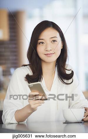 Japanese woman with smartphone in a stylish cafe View Large Photo Image Stock Image - Japanese woman with smartphone in a stylish cafe. Fotosearch