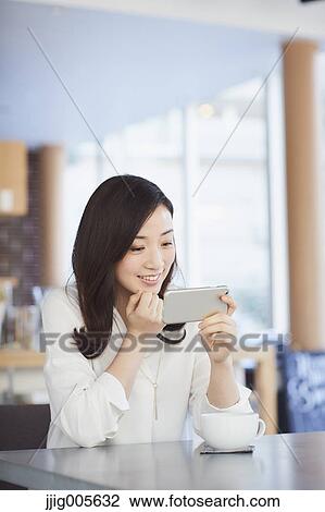 Japanese woman with smartphone in a stylish cafe View Large Photo Image Stock Image - Japanese woman with smartphone in a stylish cafe. Fotosearch
