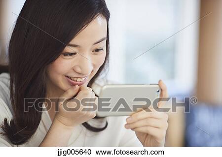 Japanese woman with smartphone in a stylish cafe View Large Photo Image Stock Image - Japanese woman with smartphone in a stylish cafe. Fotosearch