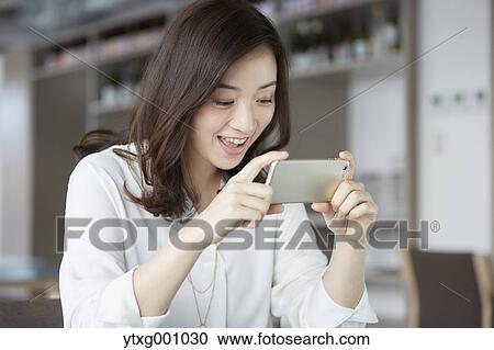 Japanese woman with smartphone in a stylish cafe View Large Photo Image Stock Image - Japanese woman with smartphone in a stylish cafe. Fotosearch