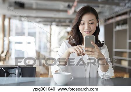Japanese woman with smartphone in a stylish cafe View Large Photo Image Stock Image - Japanese woman with smartphone in a stylish cafe. Fotosearch