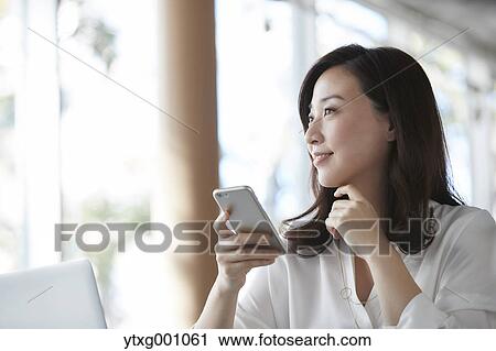 Japanese woman with smartphone in a stylish cafe View Large Photo Image Stock Image - Japanese woman with smartphone in a stylish cafe. Fotosearch