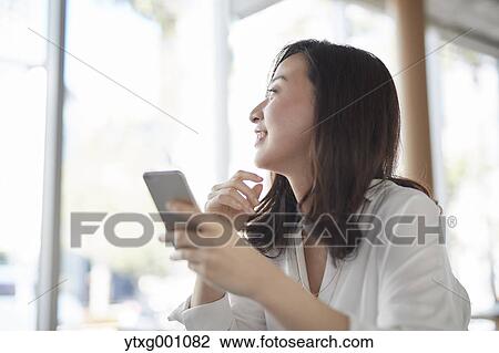 Japanese woman with smartphone in a stylish cafe View Large Photo Image Stock Image - Japanese woman with smartphone in a stylish cafe. Fotosearch