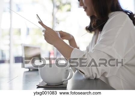 Japanese woman with smartphone in a stylish cafe View Large Photo Image Stock Image - Japanese woman with smartphone in a stylish cafe. Fotosearch