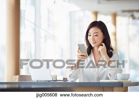 Japanese woman with smartphone in a stylish cafe View Large Photo Image Stock Photo - Japanese woman with smartphone in a stylish cafe. Fotosearch