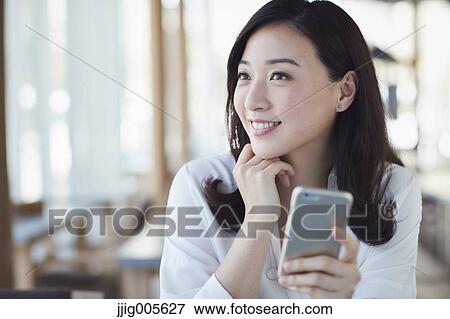 Japanese woman with smartphone in a stylish cafe View Large Photo Image Stock Photo - Japanese woman with smartphone in a stylish cafe. Fotosearch