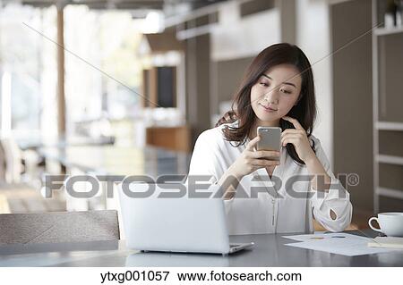 Japanese woman with smartphone in a stylish cafe View Large Photo Image Stock Photo - Japanese woman with smartphone in a stylish cafe. Fotosearch