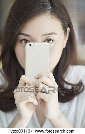 Japanese woman with smartphone in a stylish cafe View Large Photo Image Stock Photo - Japanese woman with smartphone in a stylish cafe. Fotosearch