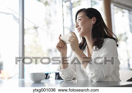 Japanese woman with smartphone in a stylish cafe View Large Photo Image Stock Photograph - Japanese woman with smartphone in a stylish cafe. Fotosearch