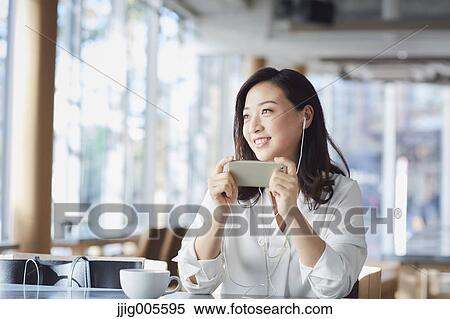 Japanese woman with smartphone in a stylish cafe View Large Photo Image Stock Photography - Japanese woman with smartphone in a stylish cafe. Fotosearch