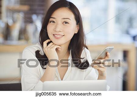Japanese woman with smartphone in a stylish cafe View Large Photo Image Stock Photography - Japanese woman with smartphone in a stylish cafe. Fotosearch