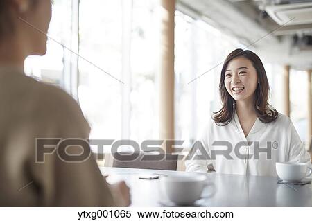 Stock Photography - Japanese women in a stylish cafe. Fotosearch