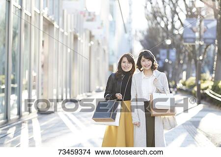 Picture - Japanese women window shopping downtown Tokyo. Fotosearch