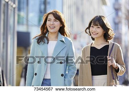 Stock Photo - Japanese women window shopping downtown Tokyo. Fotosearch