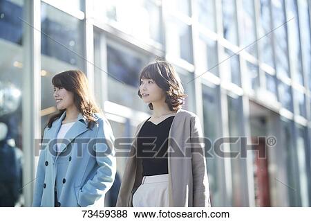 Stock Photo - Japanese women window shopping downtown Tokyo. Fotosearch