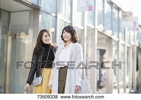 Stock Photo - Japanese women window shopping downtown Tokyo. Fotosearch