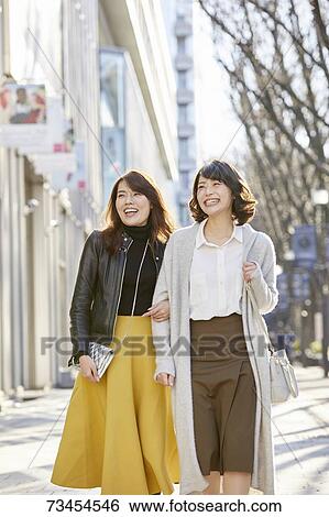 Stock Photograph - Japanese women window shopping downtown Tokyo. Fotosearch