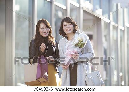 Stock Photograph - Japanese women window shopping downtown Tokyo. Fotosearch