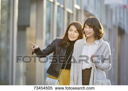 Stock Photography - Japanese women window shopping downtown Tokyo. Fotosearch