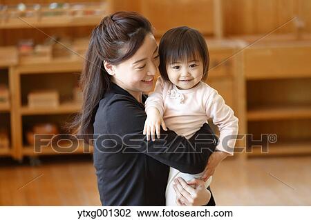 Stock Image - Mother picking up her kid at Japanese kindergarten. Fotosearch