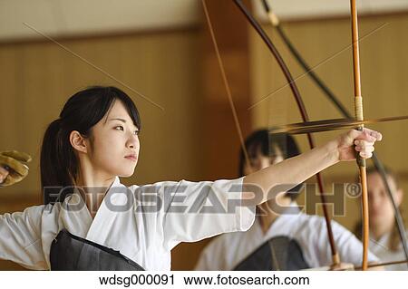 Stock Image - Multi-ethnic group of Japanese traditional archery athletes practicing. Fotosearch