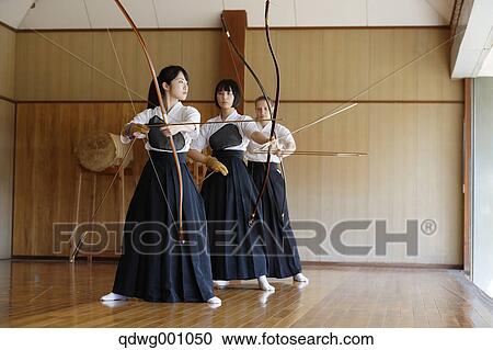 Stock Image - Multi-ethnic group of traditional archery athletes practicing. Fotosearch