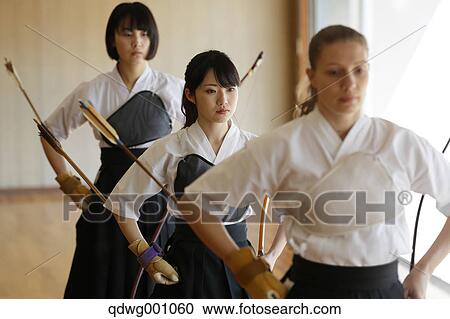 Stock Image - Multi-ethnic group of traditional archery athletes practicing. Fotosearch