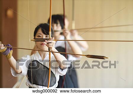 Stock Image - Multi-ethnic group of traditional archery athletes practicing. Fotosearch