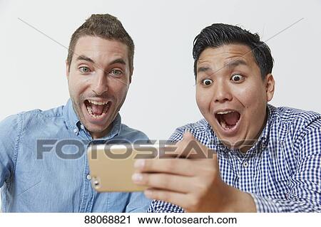 Stock Image - Multi-ethnic men using smartphone. Fotosearch