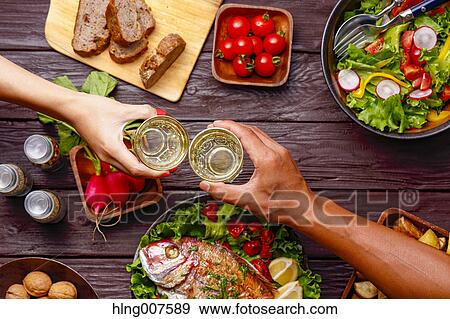 People hands toasting over wooden table with colorful dishes View Large Photo Image Stock Photo - People hands toasting over wooden table with colorful dishes. Fotosearch