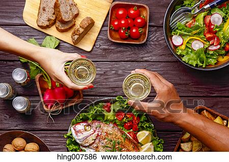 People hands toasting over wooden table with colorful dishes View Large Photo Image Stock Photograph - People hands toasting over wooden table with colorful dishes. Fotosearch