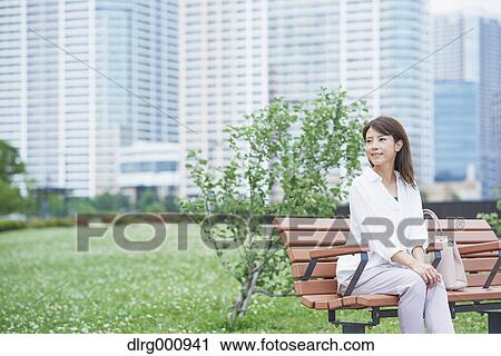 Stock Image - Portrait of young Japanese woman in a city park, Tokyo, Japan. Fotosearch