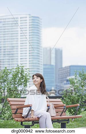 Stock Image - Portrait of young Japanese woman in a city park, Tokyo, Japan. Fotosearch