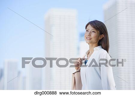 Stock Photo - Portrait of young Japanese woman downtown Tokyo, Japan. Fotosearch