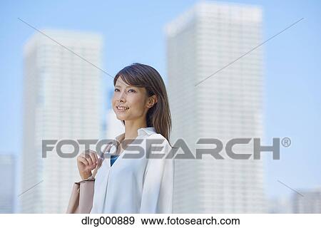 Stock Photo - Portrait of young Japanese woman downtown Tokyo, Japan. Fotosearch