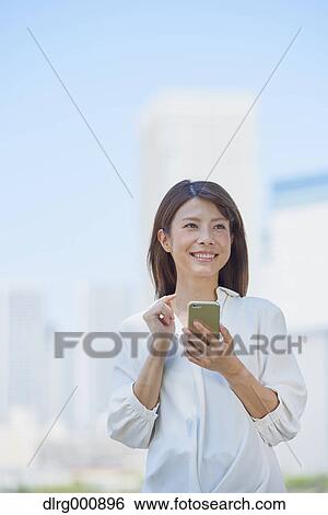Stock Photograph - Portrait of young Japanese woman downtown Tokyo, Japan. Fotosearch
