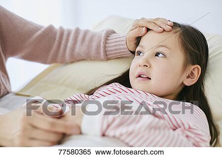 Stock Photography - Sick Japanese kid in bed. Fotosearch