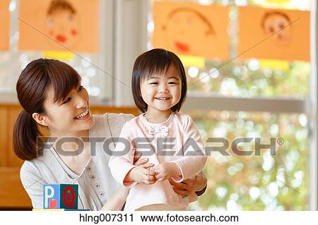 Stock Image - Teacher with kid at Japanese kindergarten. Fotosearch