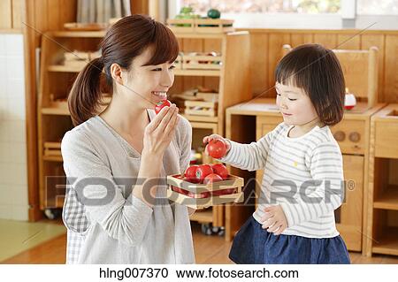 Stock Image - Teacher with kid at Japanese kindergarten. Fotosearch