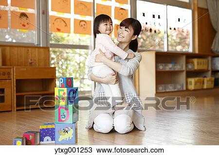 Stock Image - Teacher with kid at Japanese kindergarten. Fotosearch