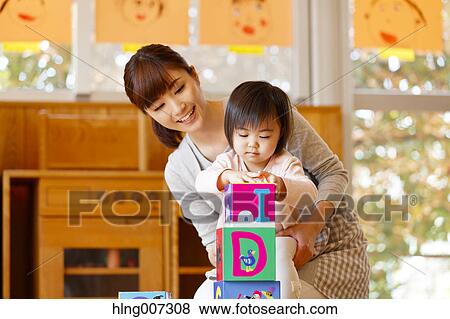 Stock Photo - Teacher with kid at Japanese kindergarten. Fotosearch