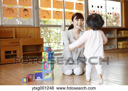 Stock Photo - Teacher with kid at Japanese kindergarten. Fotosearch