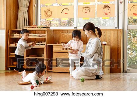 Stock Photo - Teacher with kids at Japanese kindergarten. Fotosearch