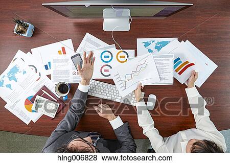 Stock Photo - Top view of Japanese businesspeople talking in meeting room. Fotosearch