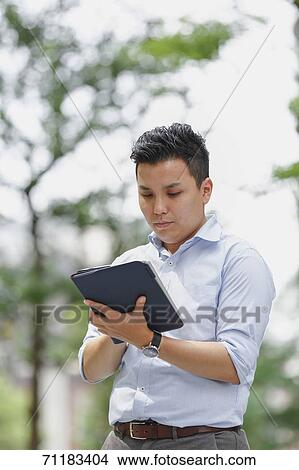 Picture - Young Japanese businessman downtown Tokyo. Fotosearch